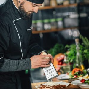 preparing-vegetarian-burrito-chef-grating-cheese-w-KPKW73T